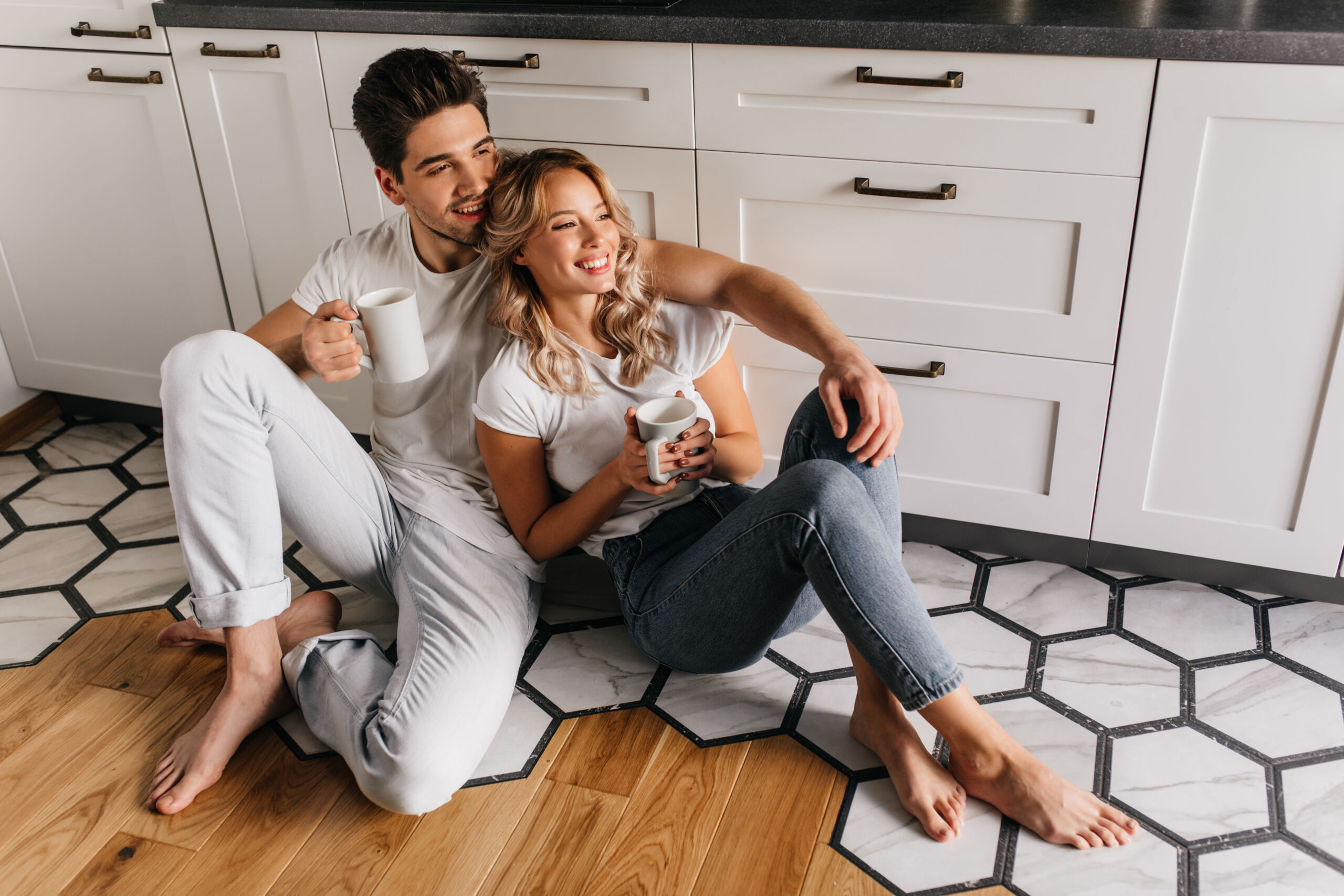 Chilling young people drinking coffee in weekend morning. Indoor photo of smiling couple relaxing during breakfast.